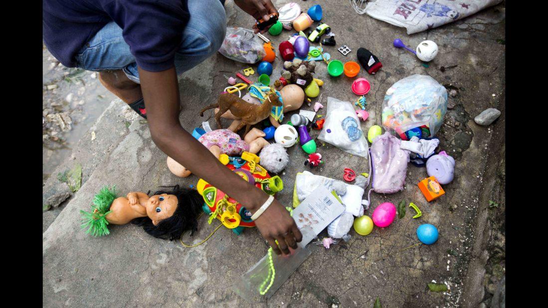 A man dries toys recovered from the debris left by Hurricane Matthew in Les Cayes, Haiti, on Thursday, October 6.