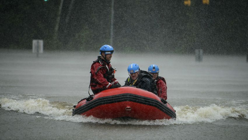 A water rescue team heads to shore at the onramp of MLK Freeway after rescuing Derrick Williams from the flood waters on Robeson Street on Saturday, Oct. 8, 2016, in Fayetteville, N.C.  A fast-weakening Hurricane Matthew continued its march along the Atlantic coast Saturday, lashing two of the South's most historic cities and some of its most popular resort islands, flattening trees, swamping streets and knocking out power to hundreds of thousands.
