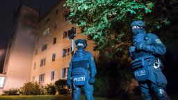 Policemen in protective cllothing stand in front of at a residential building in Chemnitz, eastern Germany, on October 8, 2016.
Police found several hundred grams of "explosive materials" in the east German apartment of a Syrian man suspected of planning a bomb attack, and arrested three people connected to him. 