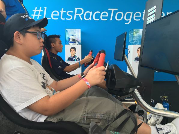 Fans trying their hand a driving game in the Renault e.dams stand. 