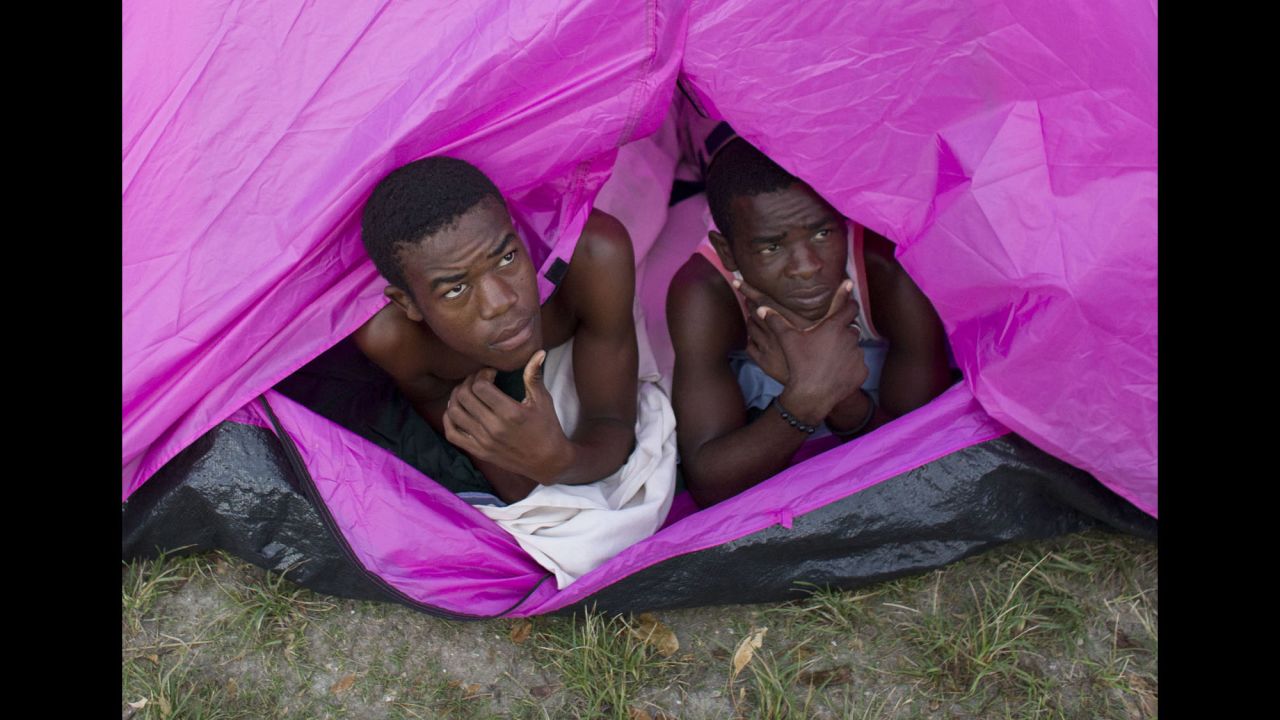 Two young men who lost their homes awake from a tent in the courtyard of a school where they took shelter in Port Salut on October 10.