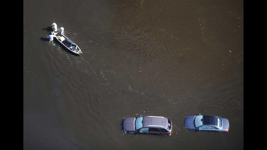 People wade through floodwaters with a boat in Nichols, South Carolina, on Monday, October 10. Hurricane Matthew caused flooding and damage in the Southeast -- from Florida to North Carolina -- after slamming Haiti and other countries in the Caribbean.