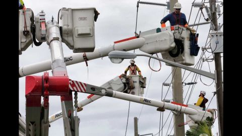 Workers repair downed power lines in Daytona Beach, Florida, on October 10.