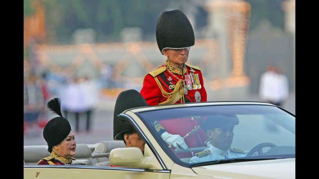 The King reviews an honor guard with Queen Sirikit and Crown Prince Vajiralongkorn during the annual military parade to celebrate his birthday in 2006.