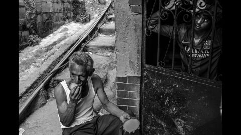 A man eats a mango for lunch in front of his shack in Petare, the largest slum in Caracas.