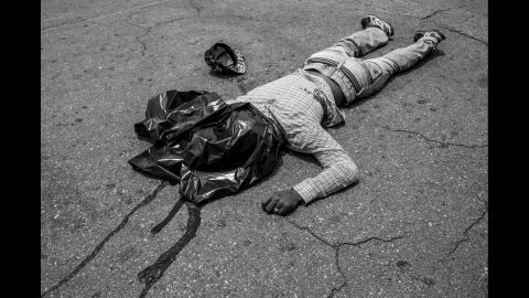 A young man lies dead in front of a supermarket where he allegedly just tried to rob a man, who reacted by shooting him in the stomach.
