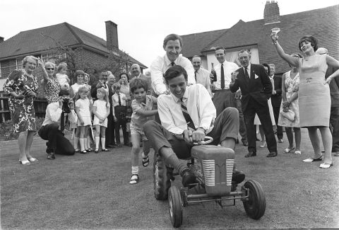 Graham and Damon Hill are the only father-son world champions in F1. Graham (center) is pictured with Damon pushing reigning world champion Jim Clark around on a toy tractor in 1966.