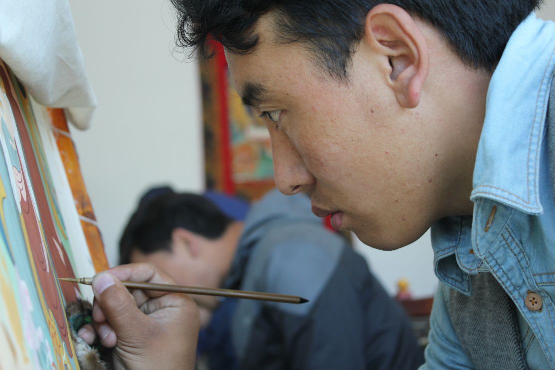 An art student paints a traditional thangka at an art school CNN was taken to on a government-approved tour.