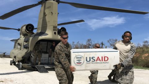 US troops unload plastic tarps for emergency shelters and rice from two US Army Chinooks  outside the hurricane-stricken town of Jeremie.  