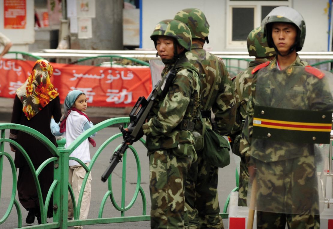 Chinese paramilitary policemen stand guard on a street in the Uyghur district of Urumqi city, Xinjiang, in July 2009.