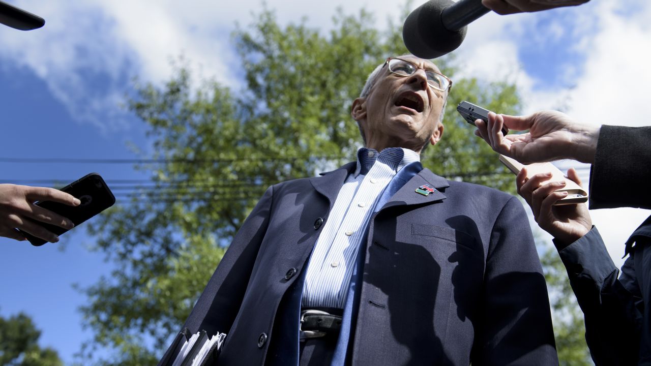 John Podesta talks to reporters as he walks to Democratic presidential nominee Hillary Clinton's Washington, DC, home October 5, 2016.