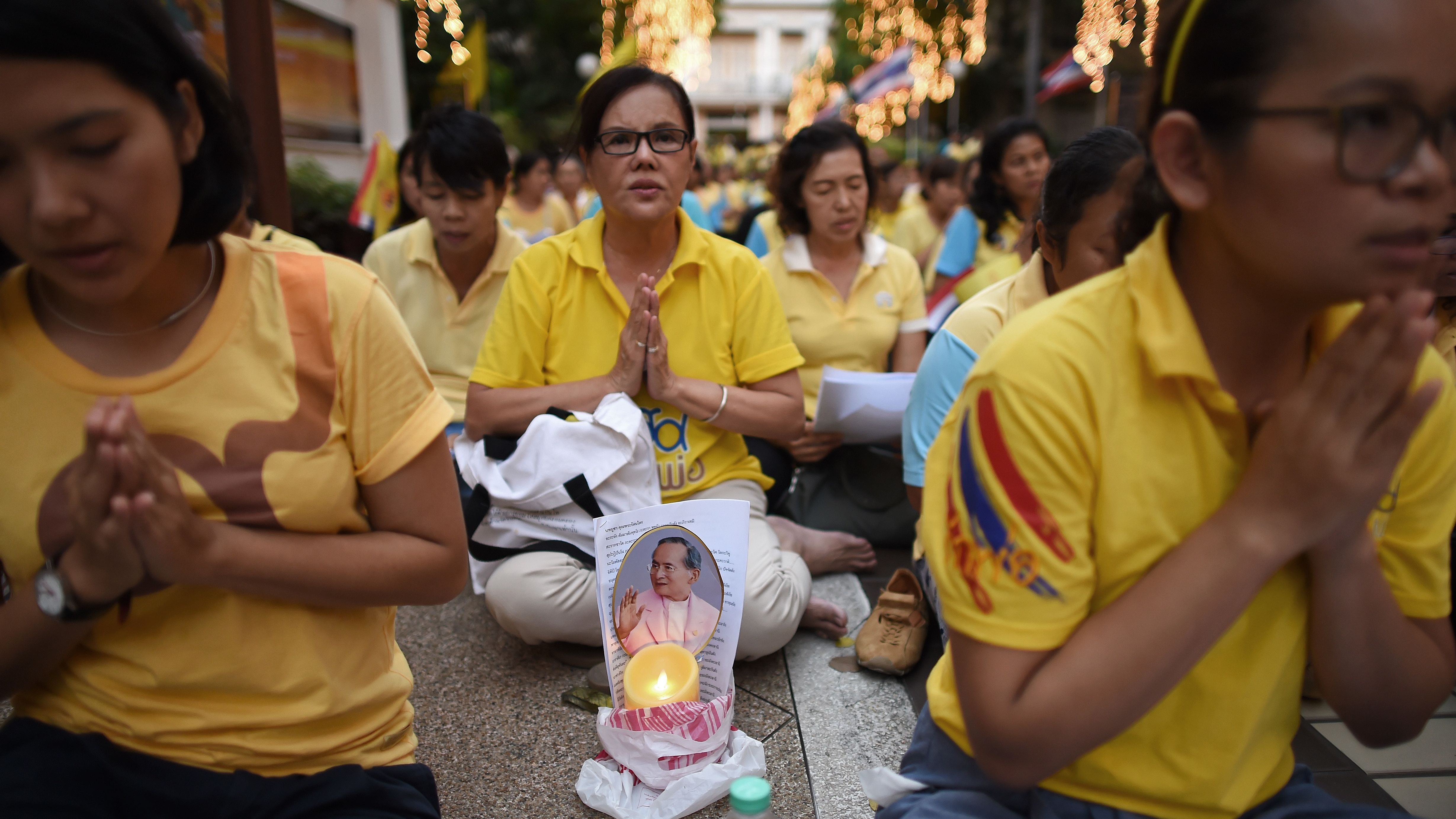 Thais dressed in yellow pray on the ruler's 88th birthday outside a Bangkok hospital in December. 