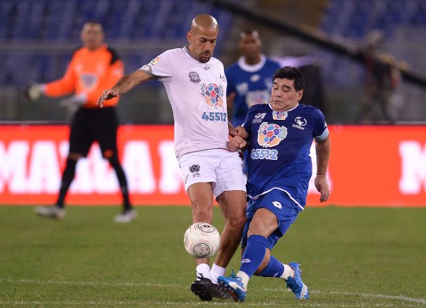 Diego Maradona clashes with Juan Sebastian Veron (left) during the "United for Peace" match in Rome, leading to the former being helped from the pitch enraged at half-time. Pope Francis helped organize the game, which featured footballing greats from around the world.