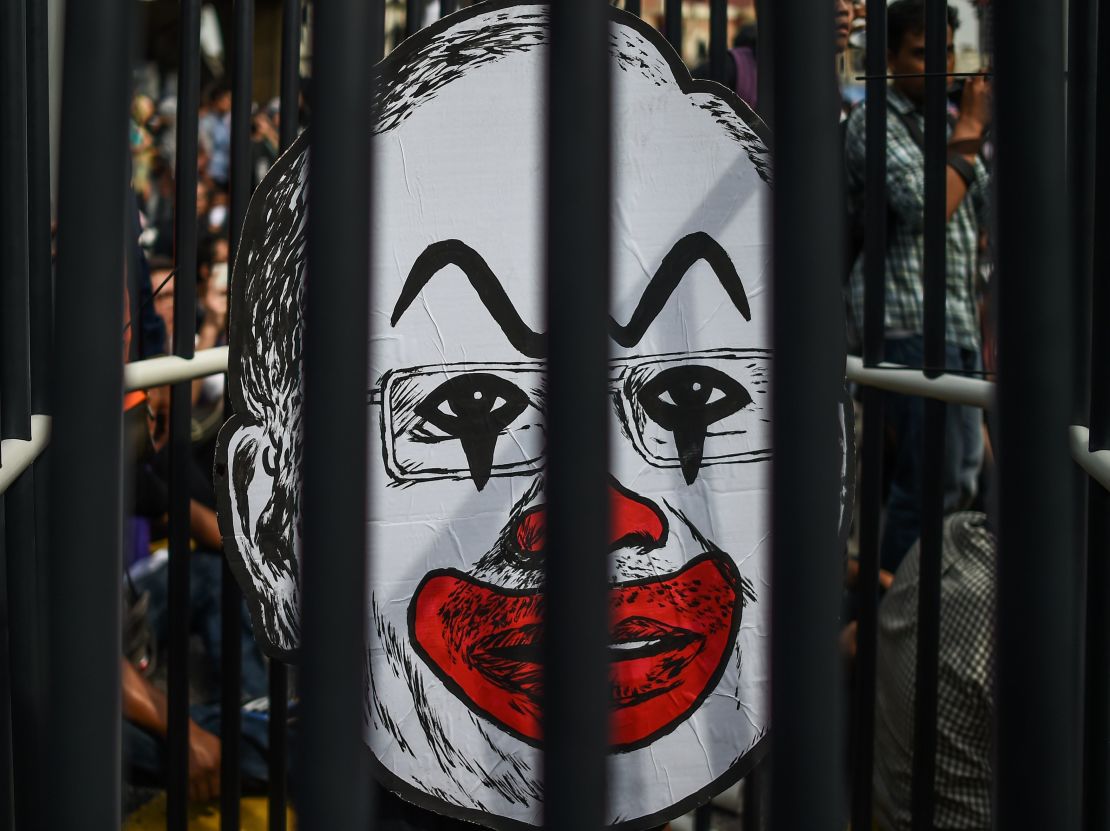 A student activist holds up a clown-faced caricature of Malaysian Prime Minister Najib Razak behind mock bars during a protest over a financial scandal involving state fund, 1MDB, in Kuala Lumpur on August 27, 2016. 