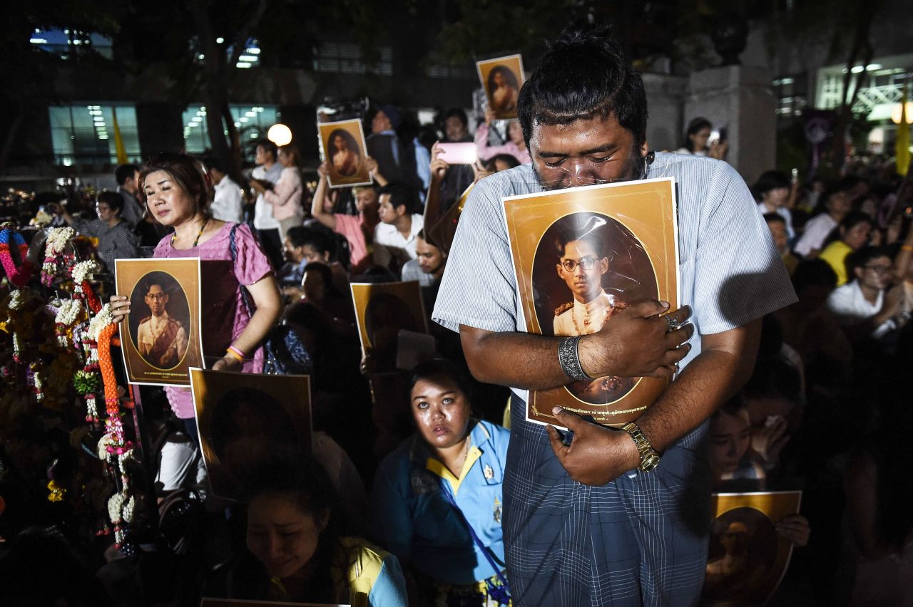 People react to news of the King's death outside Siriraj Hospital in Bangkok on Thursday.