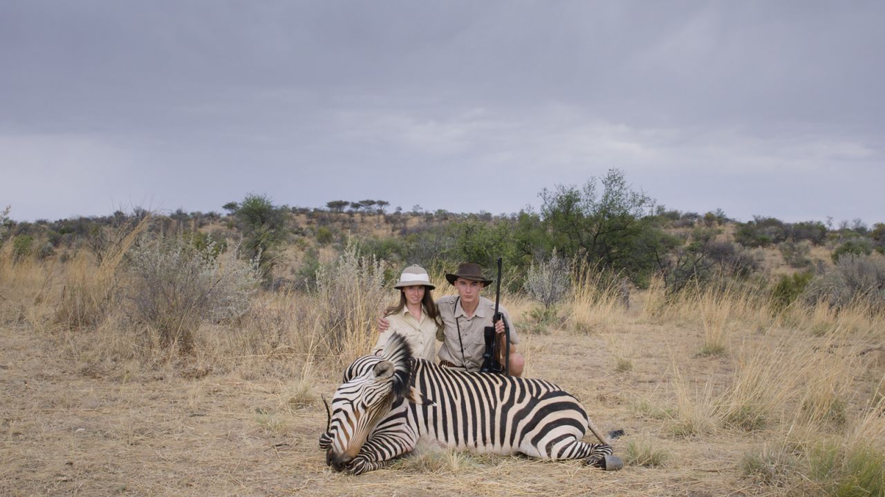 Two young hunters crouch over a dead zebra at the Leopard Lodge, Namibia.