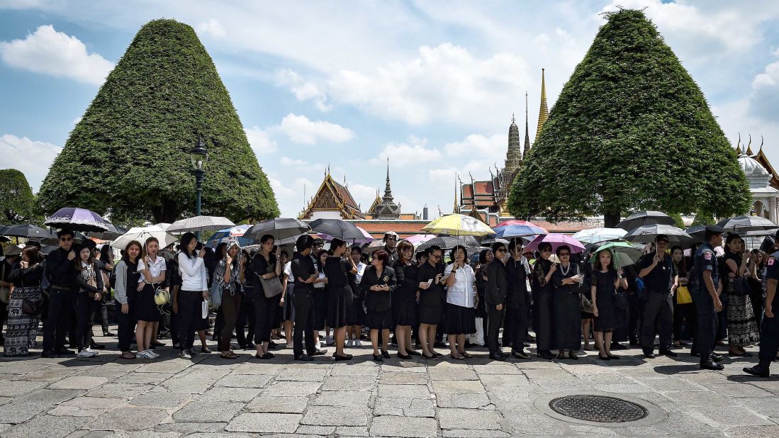 People dressed mostly in black wait outside the Grand Palace to pay respects to the King on October 14.