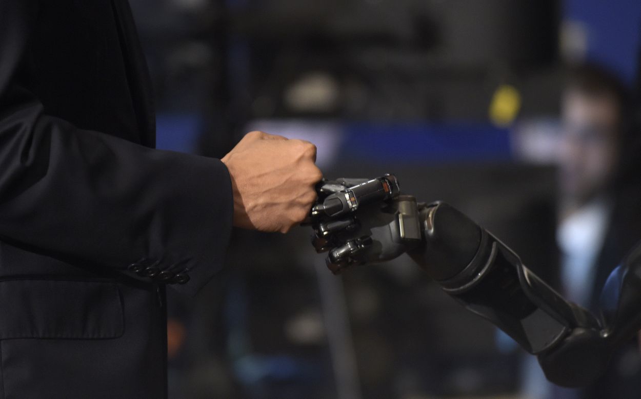 President Barack Obama fist bumps with Nathan Copeland during the White House Frontiers Conference -- an event that explores the future of innovation around the globe -- in Pittsburgh, Pennsylvania, on Thursday, October 13. Copeland is paralyzed and uses a robotic arm controlled by a brain chip, which allows him to "feel."