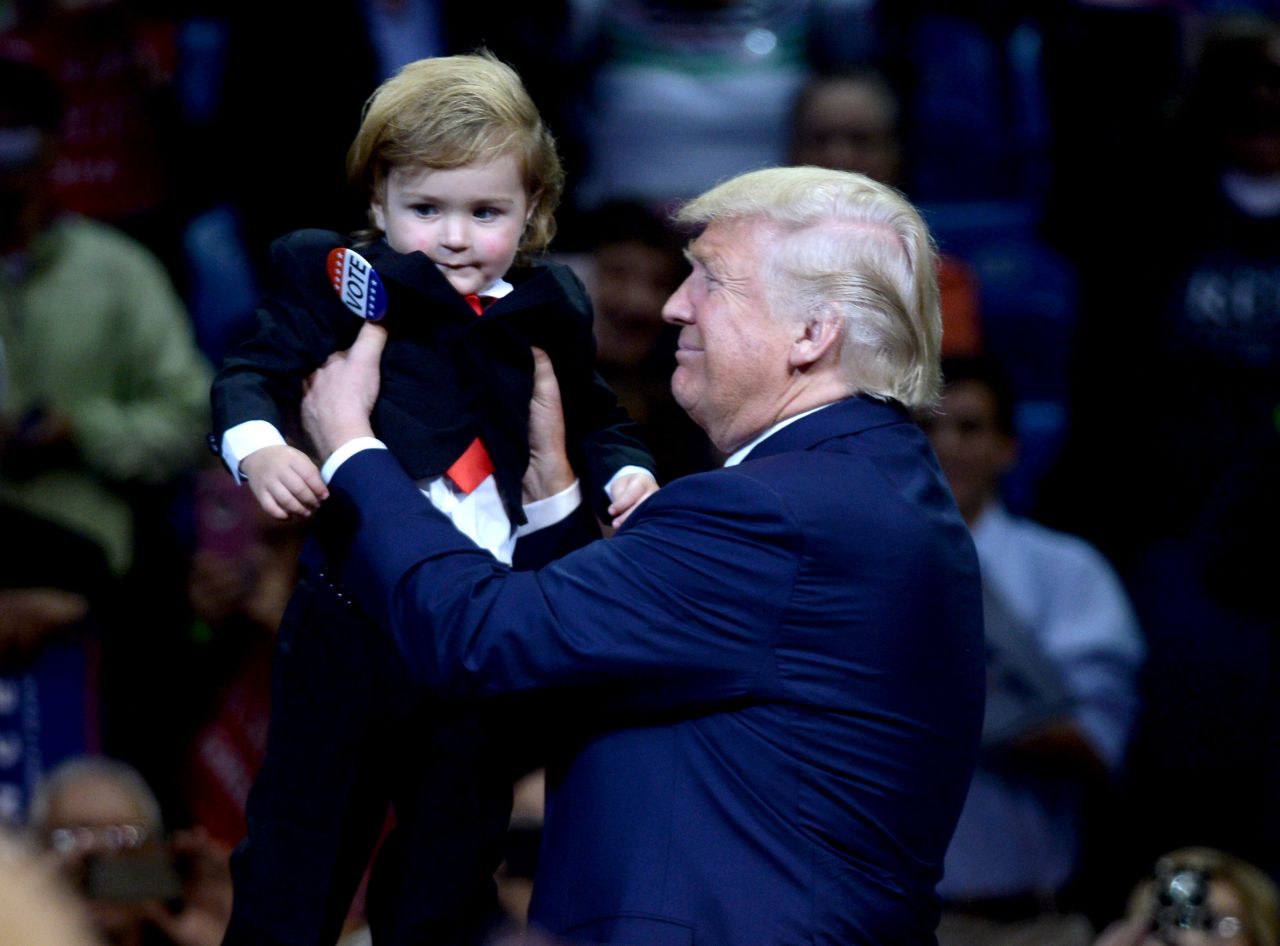 Republican presidential nominee Donald Trump carries a 2-year-old boy named Hunter Tirpak, who was dressed like Trump, at a rally in Wilkes-Barre, Pennsylvania, on Monday, October 10. 