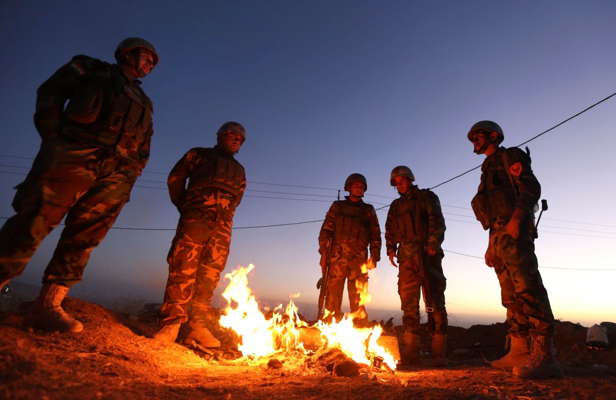 Members of the Iraqi coalition gather around a fire at Zardak mountain ahead of the offensive.