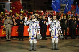 Chinese astronauts Jing Haipeng, right, and Chen Dong, left, wave farewell to the crowd before getting on Shenzhou 11 on Oct. 17, 2016.