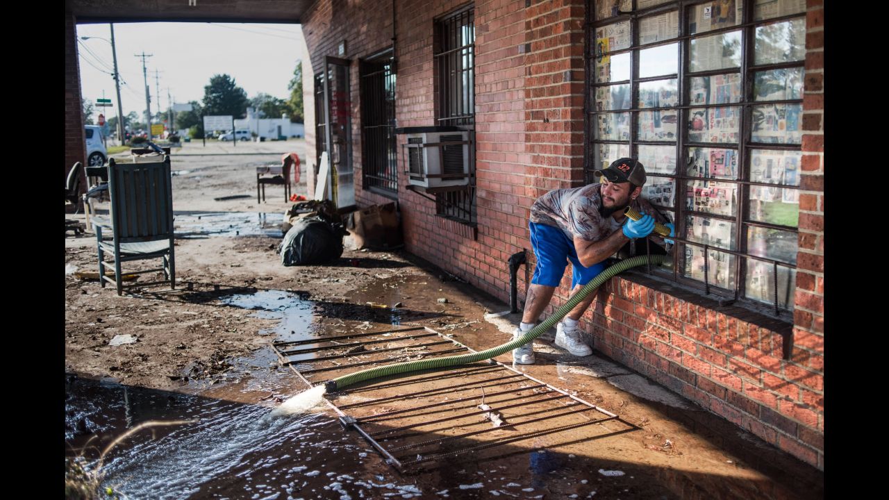 A man pumps floodwaters from the inside of a business on Saturday in Lumberton, the county seat of Robeson County, which was the area in North Carolina most affected by the storm. 