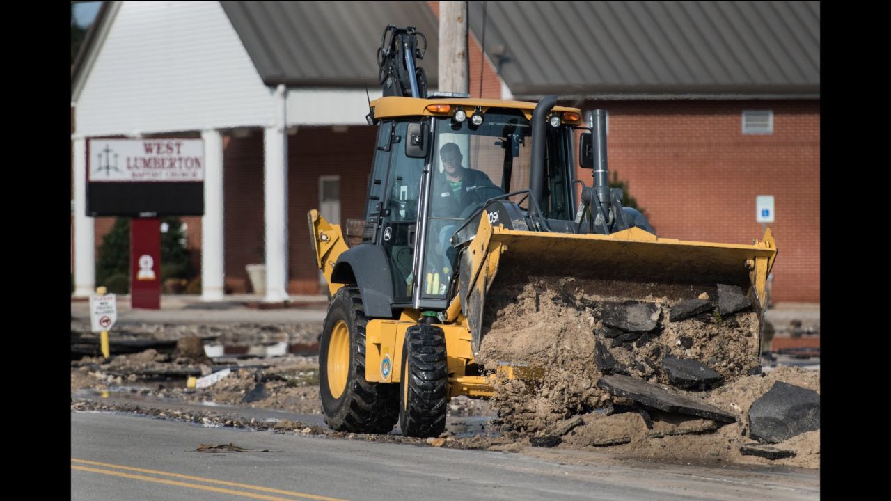 Heavy equipment is used to clear flood debris from the street in Lumberton.