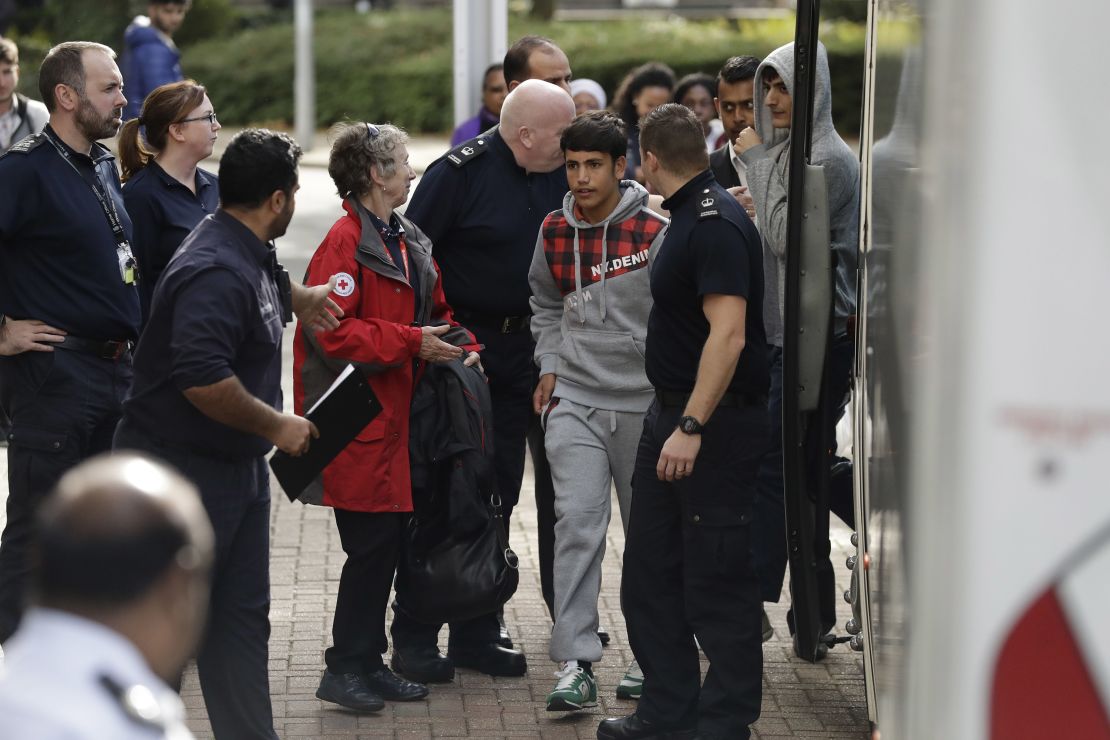 Two young migrants get off a bus at Lunar House in south London.