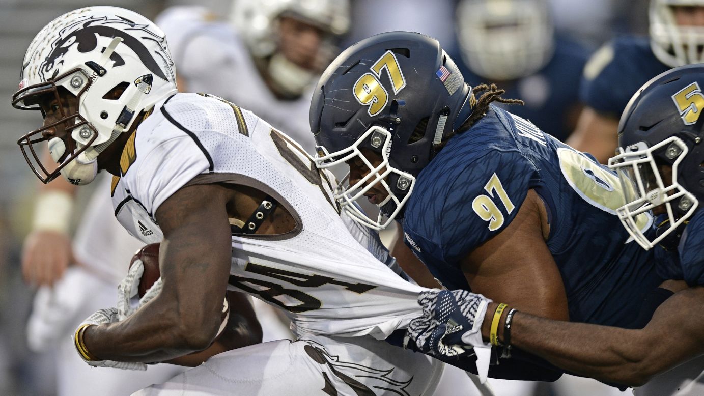 Western Michigan wide receiver Corey Davis is grabbed by Akron defenders during a college football game in Akron, Ohio, on Saturday, October 15.