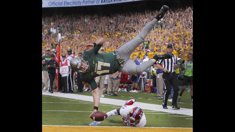 Baylor quarterback Seth Russell scores over Kansas linebacker Mike Lee during a college football game in Waco, Texas, on Saturday, October 15.