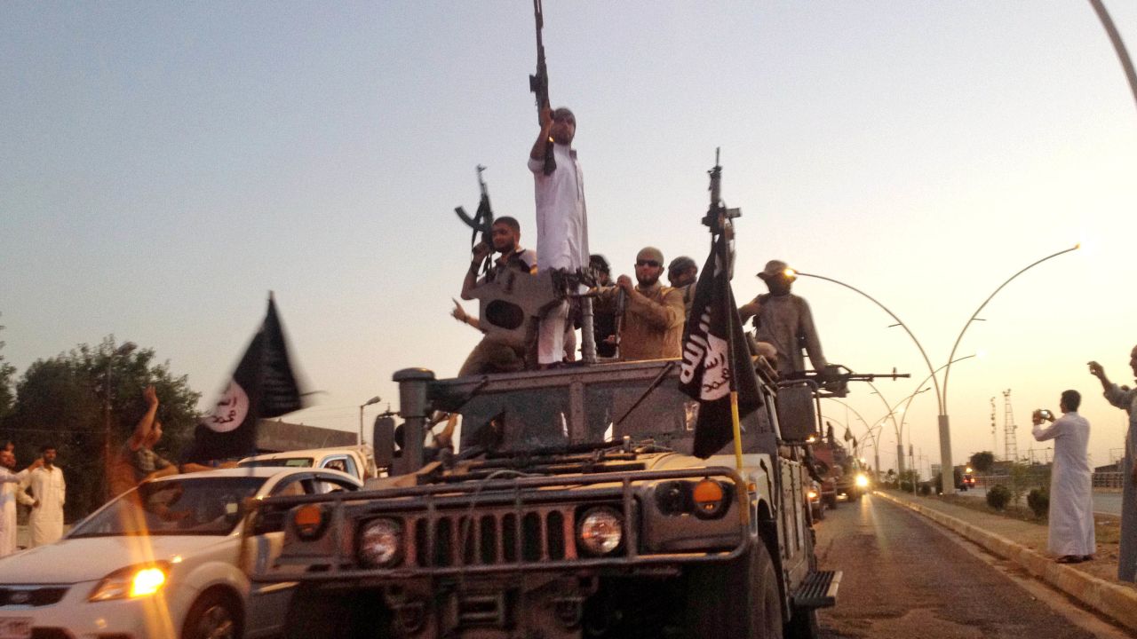 ISIS fighters parade down a main road in Mosul in 2014.