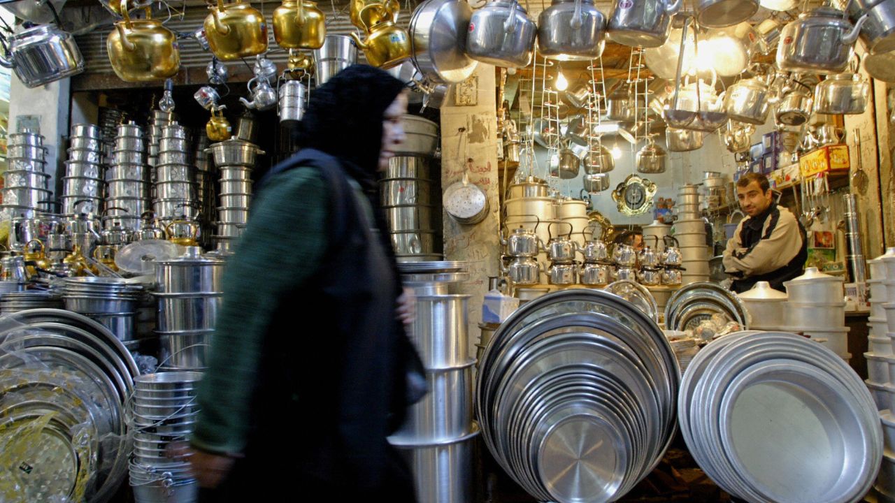 A Muslim Shiite Iraqi woman walks past a shop in Mosul in 2004, long before ISIS took the city.