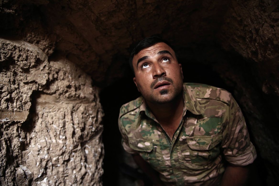 A Peshmerga fighter peers up from an underground tunnel in the liberated town of Badana on October 18. ISIS fighters have built tunnels below residential streets to escape from airstrikes.