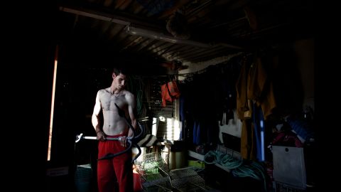 Fran, 26, checks the anchor of his small boat before heading out to sea. He is the youngest percebeiro in his family. He was forced to join the family business when Spain's real-estate market collapsed.