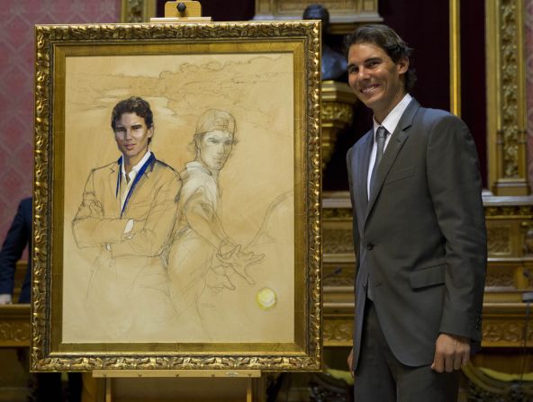 Nadal poses next to a painting depicting himself during a ceremony in Palma where he received the title of "Favorite Son of Mallorca" in December 2014. 