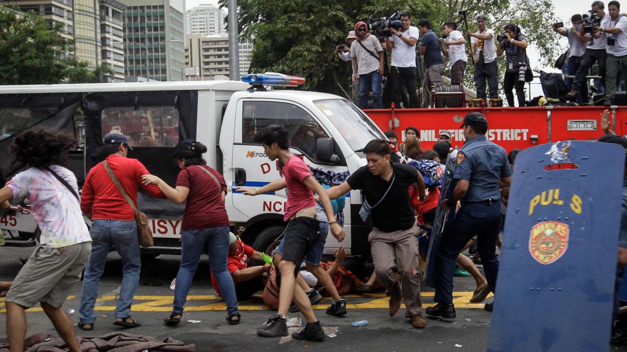 A police van runs over protesters during a protest in front of the US Embassy in Manila.