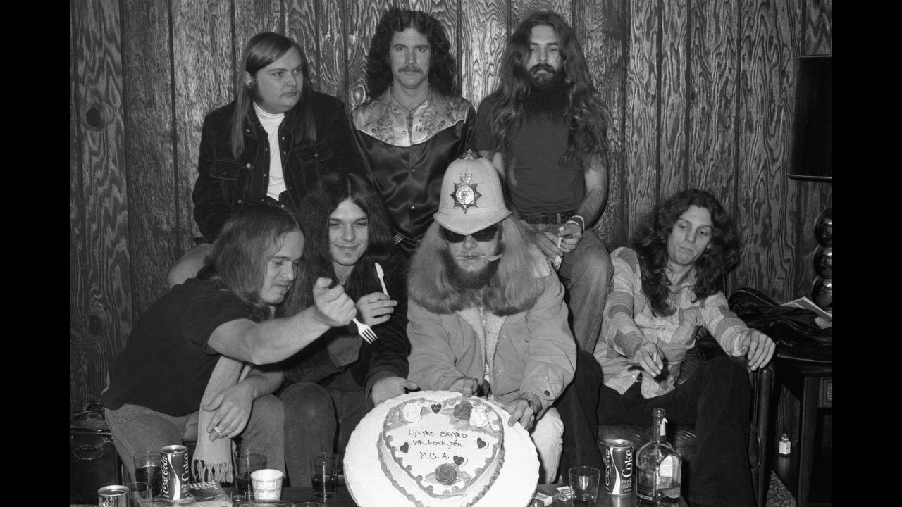 While backstage, the band enjoys a cake from MCA Records. From left are Van Zant, Ed King, Rossington, Billy Powell, Leon Wilkeson, Pyle and Collins.