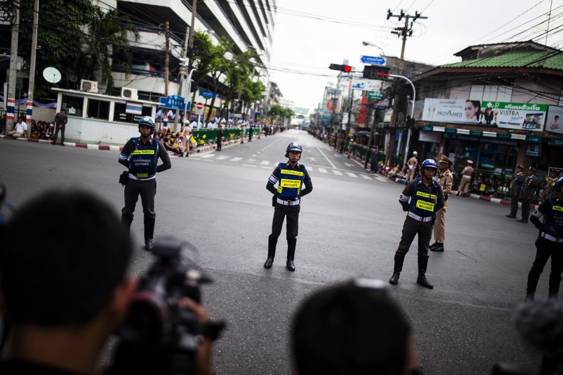 Bangkok police stand watch before King Bhumibol's funeral procession.