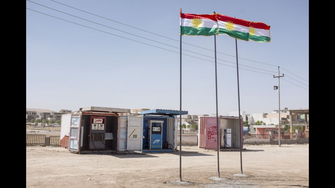 Kurdish flags fly in front of gas pumps on the side of the road. Grosso traveled between the cities of Kirkuk and Sulaymaniyah.