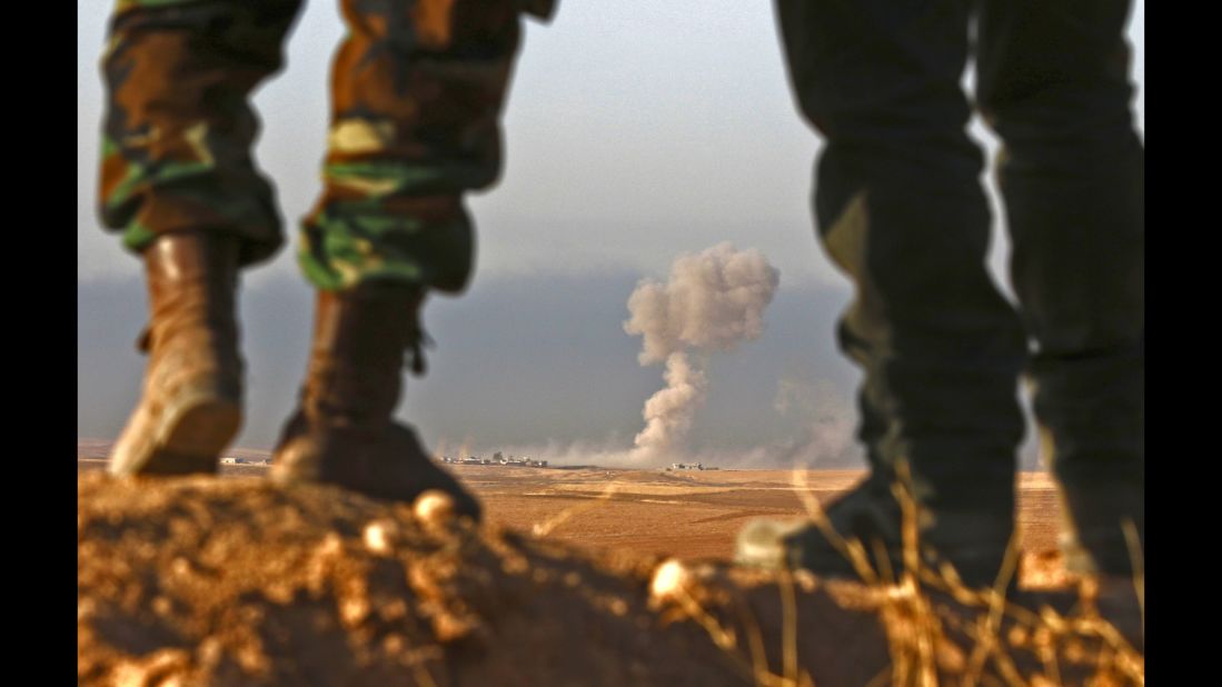 Peshmerga fighters look over a village during an assault near Bashiqa on Thursday, October 20.