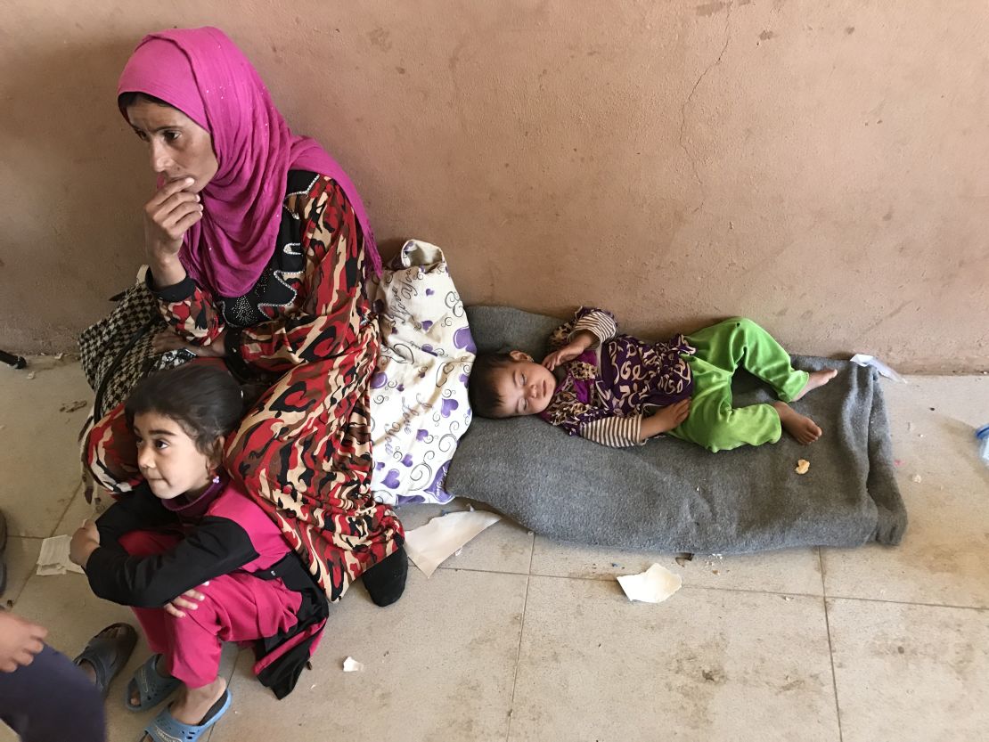A woman and her children rest at Debaka Camp, after fleeing from the path of the Mosul offensive.