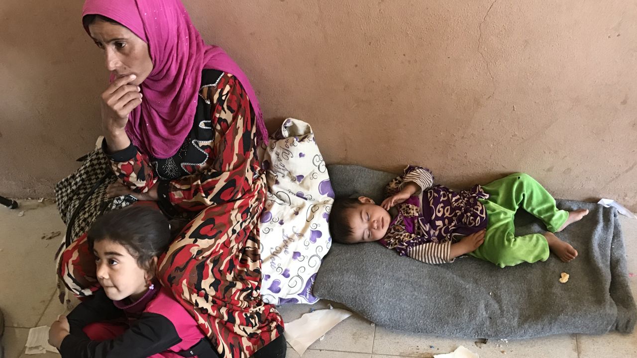 A woman and her children rest at Debaka Camp, after fleeing from the path of the Mosul offensive.