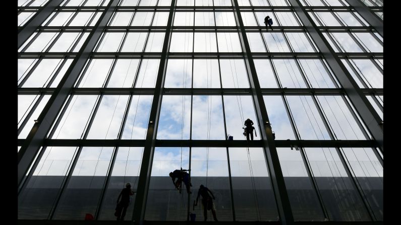 Workers clean the windows of "The Cloud," a new convention center in Rome on Wednesday, October 19.