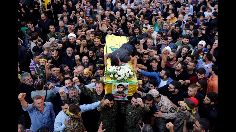 People in Beirut, Lebanon, carry the coffin of Hatem Hamadi, a Hezbollah commander killed in Syria, on Tuesday, October 18.