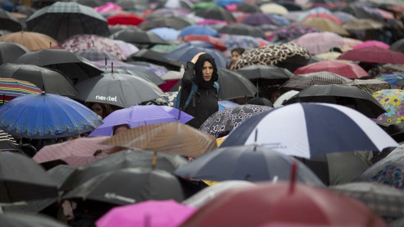 A woman looks over protesters with umbrellas during a demonstration in Buenos Aires on Wednesday, October 19. Thousands of people wearing black clothes braved torrential rain to protest the rape and killing of 16-year-old Lucia Perez, who was abducted outside her school in Mar del Plata on October 8. Protesters called the protest <a href="http://www.cnn.com/2016/10/20/americas/argentina-teen-raped-killed-trnd/" target="_blank">Black Wednesday</a> and turned it into a day to demand an end to violence against women nationwide.