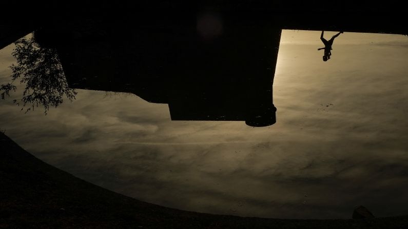 A runner is reflected on a pond in Pamplona, Spain, on Wednesday, October 19.