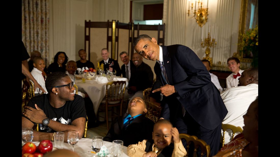 Obama takes a photo with a sleeping boy at the White House during a Father's Day ice cream social on June 14, 2013.