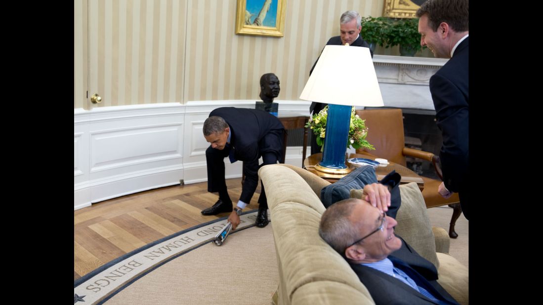 Aides laugh as the President swats a fly in the Oval Office on May 6, 2014.