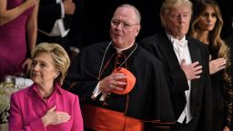 From left Democratic presidential nominee Hillary Clinton, Timothy Cardinal Dolan, Archbishop of New York, Republican presidential nominee Donald Trump and Melania Trump listen to the National Anthem during the Alfred E. Smith Memorial Foundation Dinner at Waldorf Astoria October 20, 2016 in New York, New York.