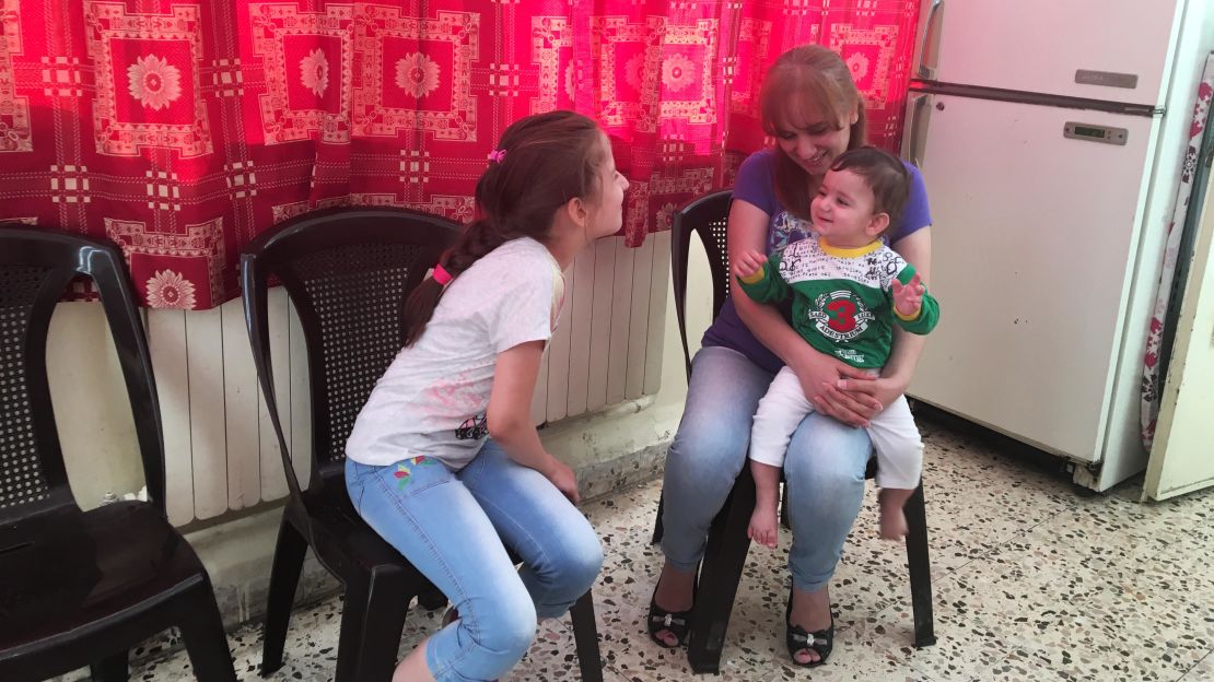 Anne plays with Rita, now nine, and her 10-month-old son Joseph, at the church in Amman, Jordan.